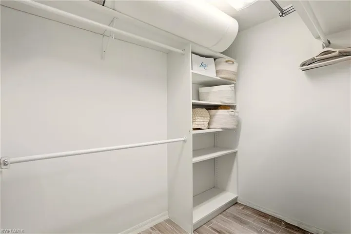 Walk in closet with wood tiled floors