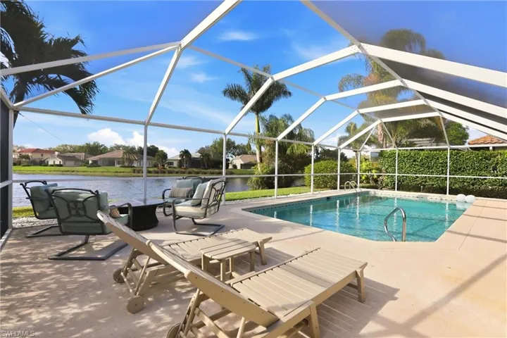 Swimming pool with a sunroom, a residential view, a patio area, a lanai, and a water view