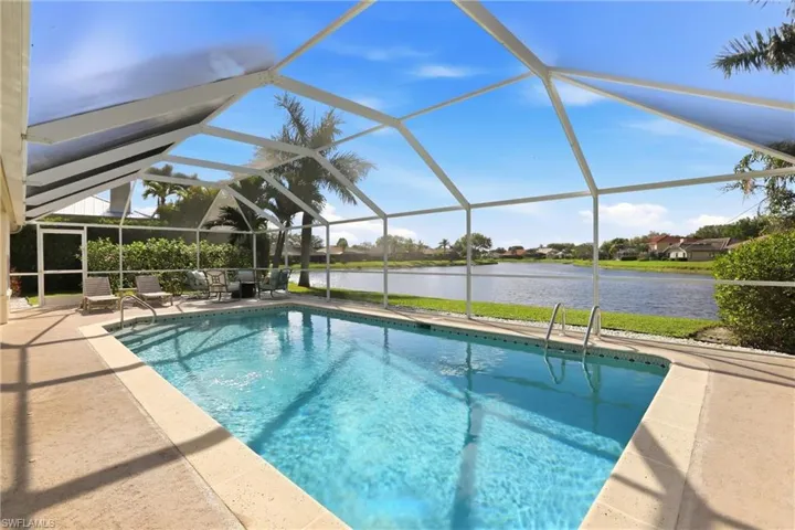 Outdoor pool featuring a lanai, a sunroom, a water view, a residential view, and a patio