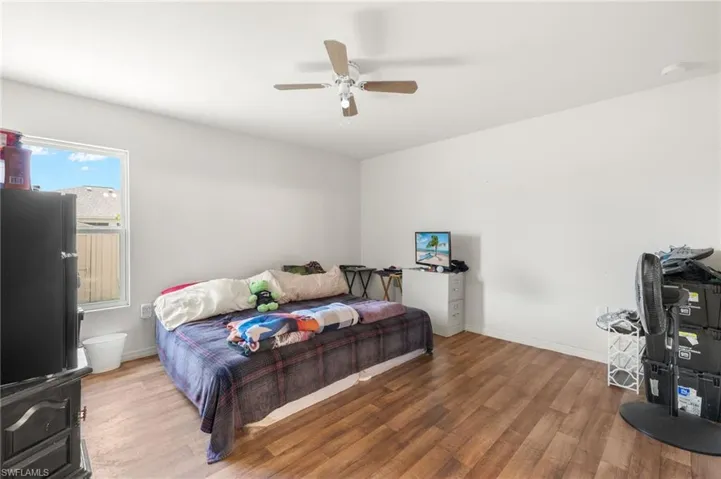 Bedroom featuring wood finished floors, baseboards, and ceiling fan