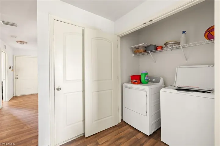 Laundry room featuring washer and dryer and dark wood-style floors