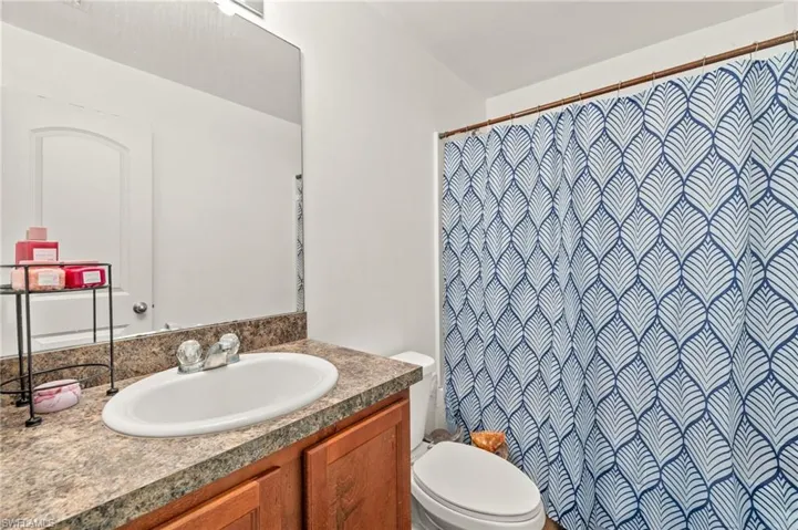 Full bath featuring toilet, vanity, and a shower with shower curtain