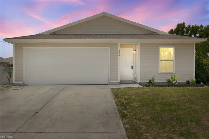 View of front of property featuring a front lawn, a shingled roof, and an attached garage