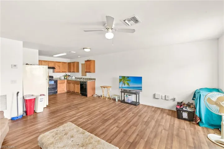Living area featuring wood finished floors, a ceiling fan, and baseboards