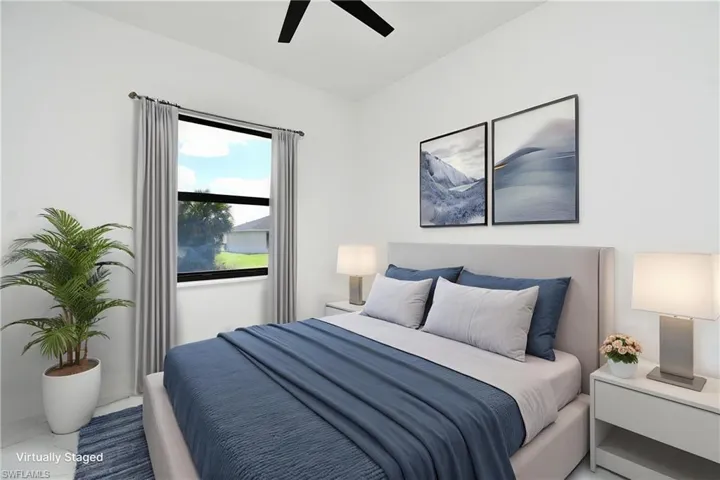 Bright bedroom featuring a large window with privacy curtains, a ceiling fan, and ample wall space