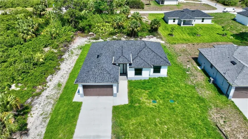 Newly constructed property featuring a dark shingle roof and a two-car garage