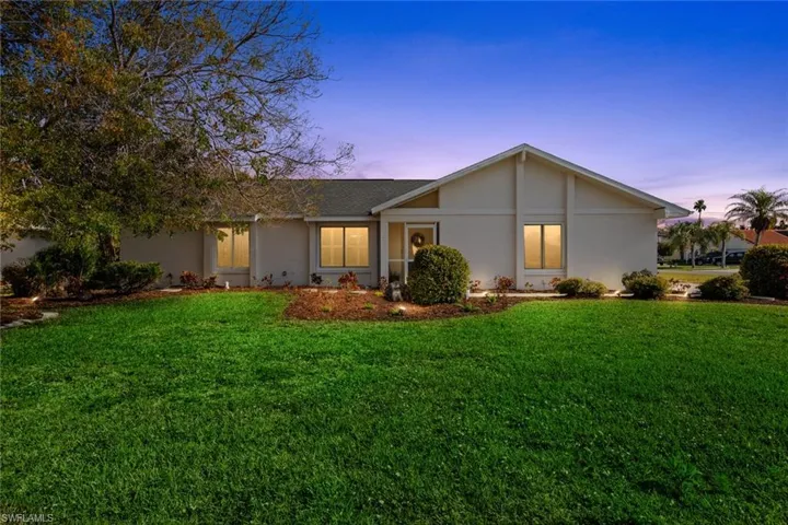 Single story home with a yard, a shingled roof, and stucco siding