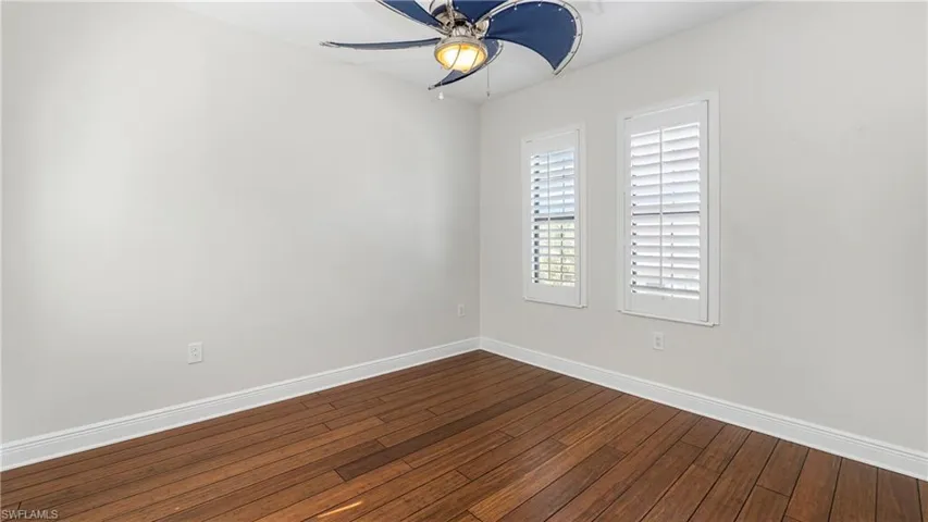 Empty room featuring hardwood / wood-style flooring and ceiling fan