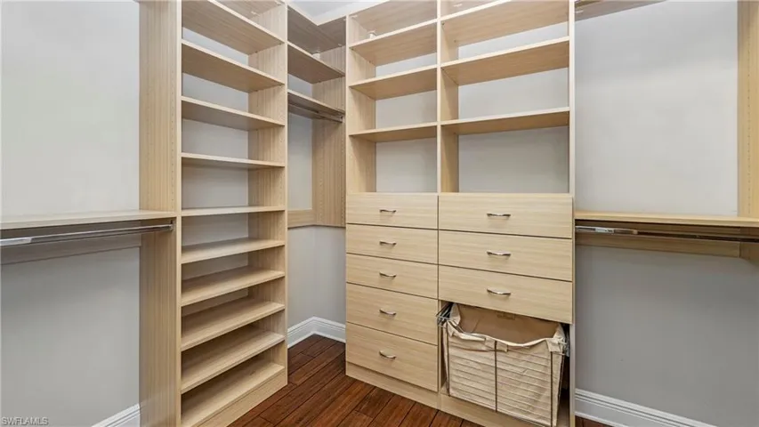 Walk in closet featuring dark wood-type flooring