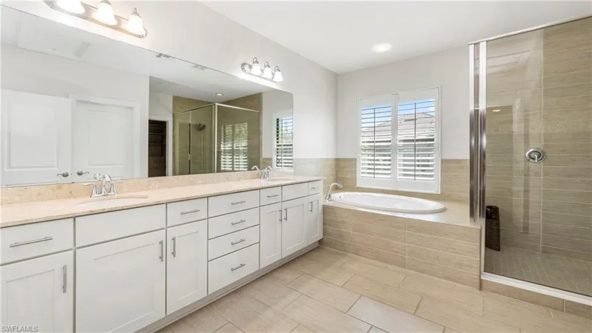 Full bath with a shower stall, a garden tub, and double vanity