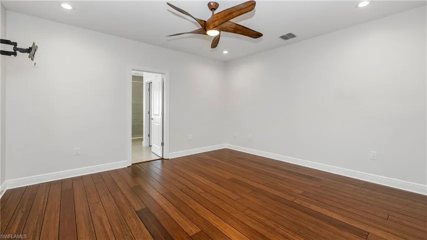 Empty room featuring a ceiling fan, dark wood-style flooring, and recessed lighting