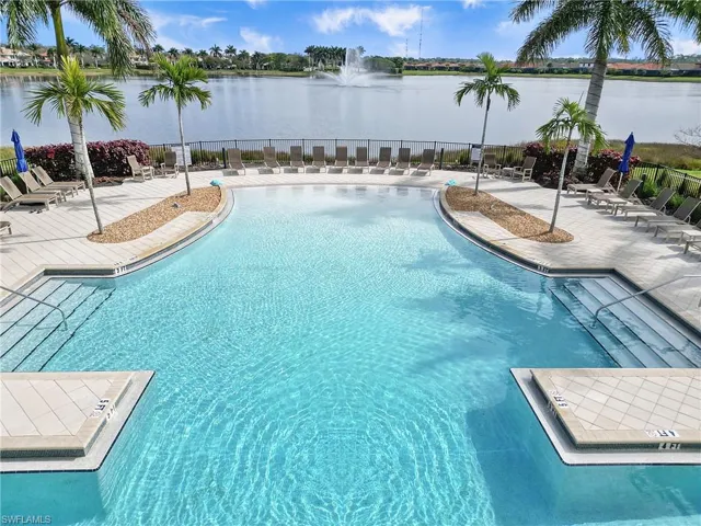 Community pool featuring a water view and a patio area