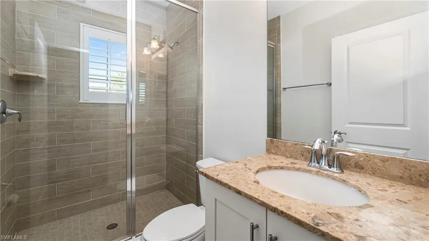 Full bathroom with vanity and a shower stall