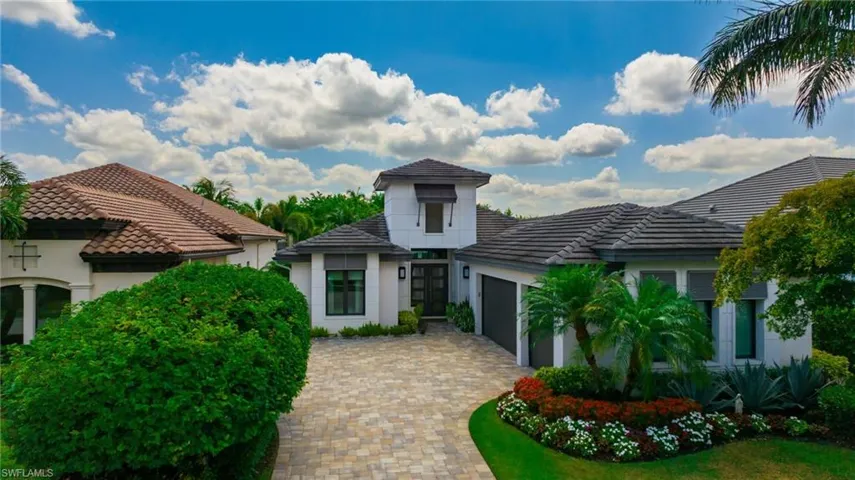 View of front of house with a garage, decorative driveway, stucco siding, and a tile roof