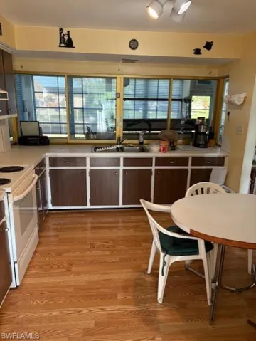 Kitchen featuring electric stove, light wood finished floors, plenty of natural light, and light countertops