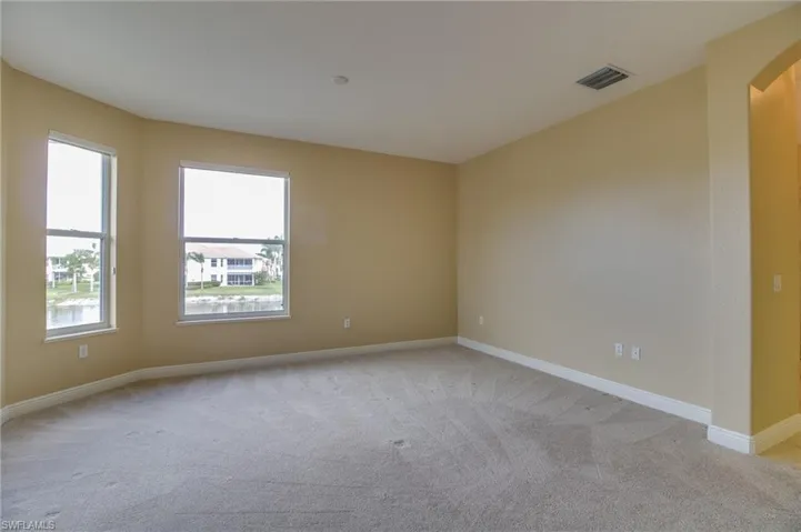 Empty room featuring light carpet and arched walkways