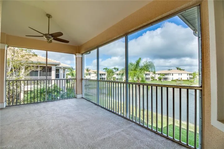 Unfurnished sunroom with vaulted ceiling, healthy amount of natural light, a water view, carpet floors, and a textured wall