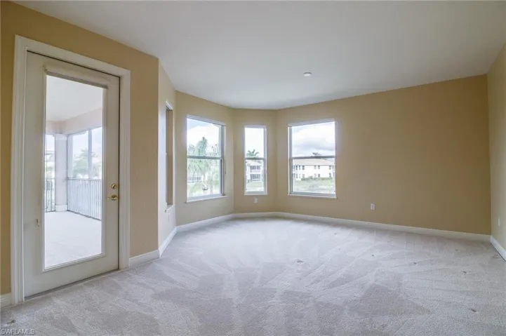 Unfurnished room with light colored carpet and baseboards