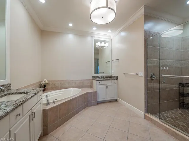 Primary bedroom en-suite with dual sinks and separate tub and shower