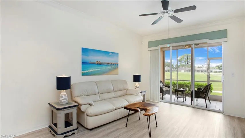 Living room featuring crown molding, light hardwood / wood-style flooring, and ceiling fan