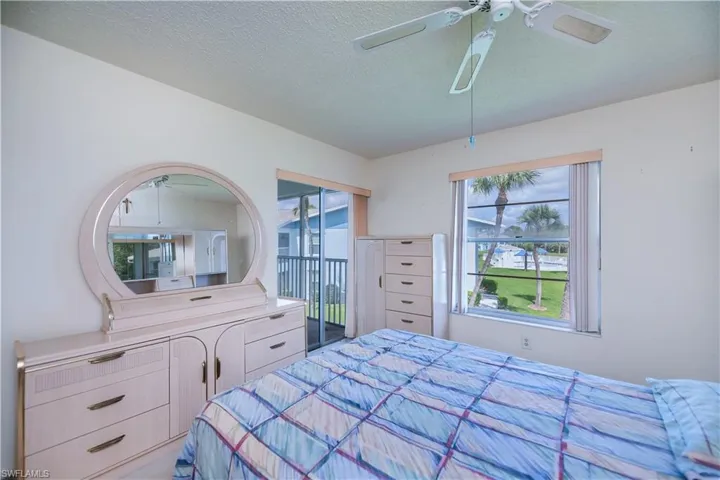Bedroom with access to exterior, a ceiling fan, and a textured ceiling