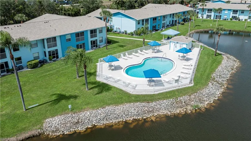 Drone / aerial view of a nearby body of water and a pool