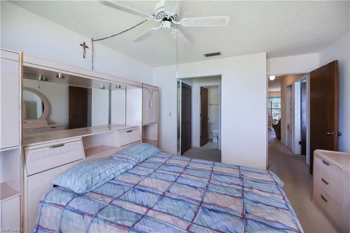 Carpeted bedroom featuring a textured ceiling and ceiling fan