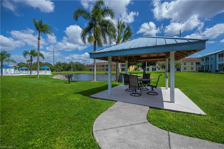 View of green lawn featuring a patio area, a gazebo, and a water view