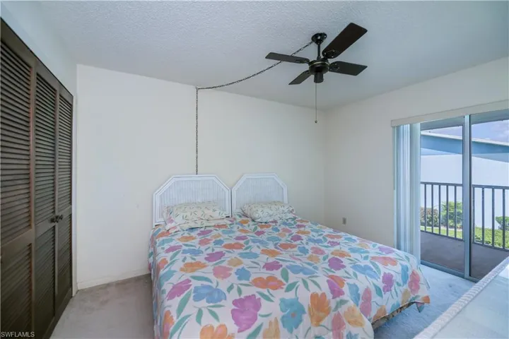 Carpeted bedroom featuring a textured ceiling, access to exterior, a closet, and ceiling fan