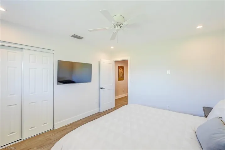 Bedroom featuring ceiling fan, light hardwood / wood-style flooring, and a closet