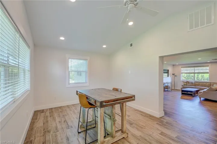 Dining area featuring light wood-type flooring, vaulted ceiling, and ceiling fan