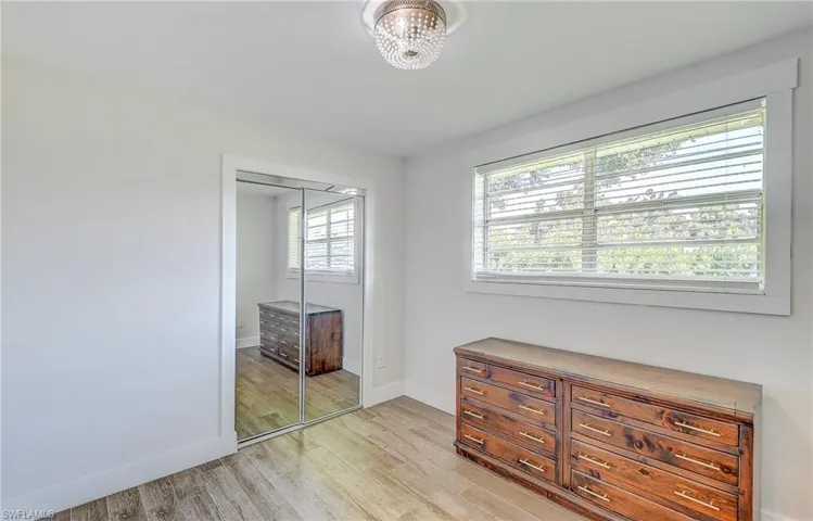 Bedroom featuring multiple windows, light hardwood / wood-style floors, and a closet