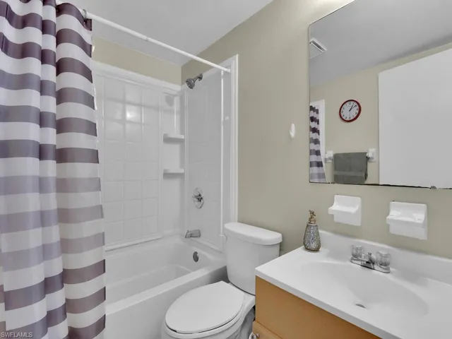 Full bathroom featuring vanity, toilet, and shower / bath combination with curtain