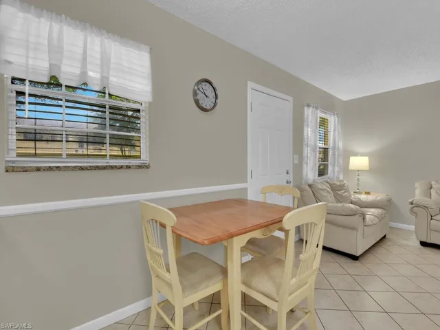 Dining space with light tile patterned floors and a textured ceiling