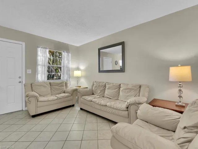 Living room featuring a textured ceiling and light tile patterned floors