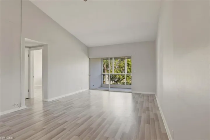 Unfurnished room featuring lofted ceiling and light wood-style flooring