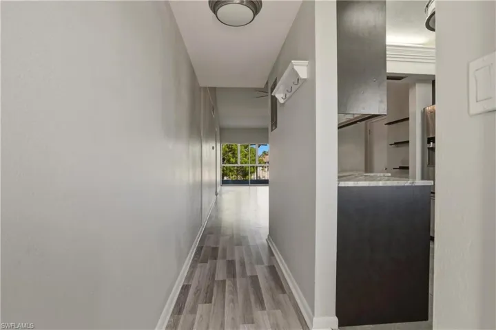 Hall with light wood-type flooring and baseboards