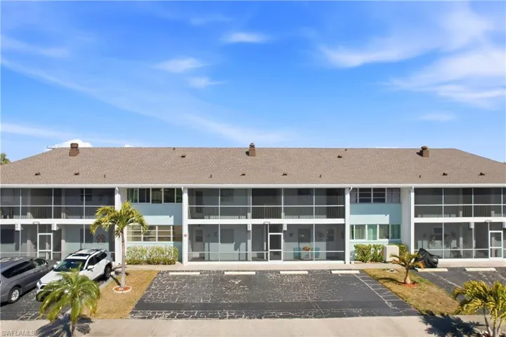 View of apartment building / complex with uncovered parking