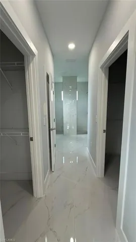 Corridor featuring light marble finish floors