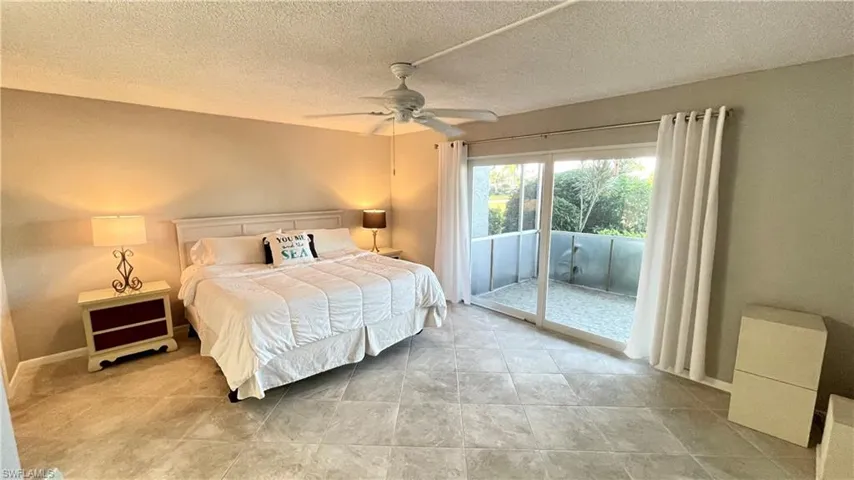 Bedroom with access to exterior, tiled floors and ceiling fan