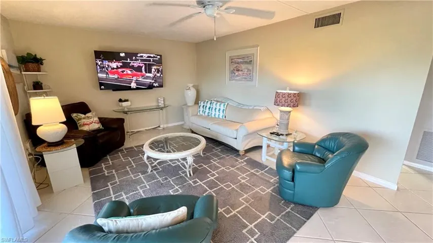 Living room featuring tile patterned floors and a ceiling fan