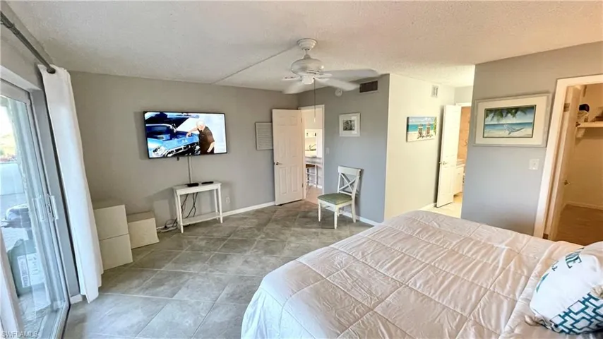 Bedroom featuring a textured ceiling, access to exterior, and a ceiling fan