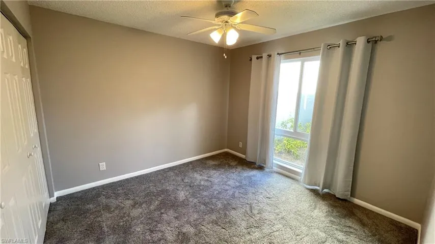 Unfurnished bedroom featuring a new carpet, a double closet, and ceiling fan