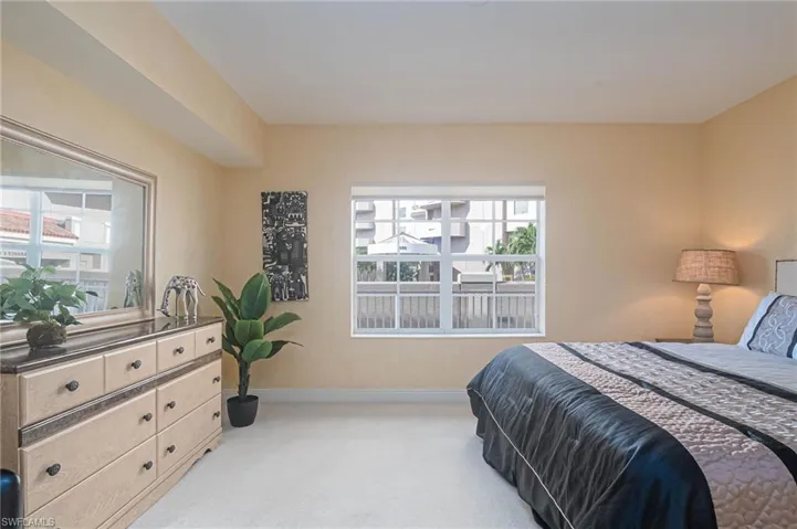 Bedroom with light carpet and baseboards