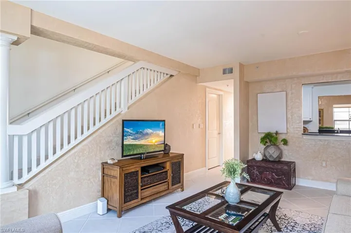 Tiled living room with baseboards and stairs