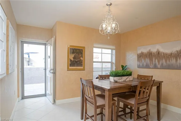 Dining area with light tile patterned floors and a chandelier