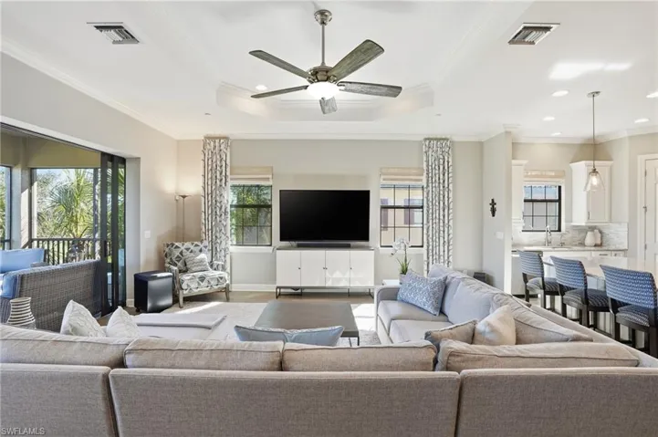 Living area featuring crown molding, a raised ceiling, ceiling fan, and recessed lighting