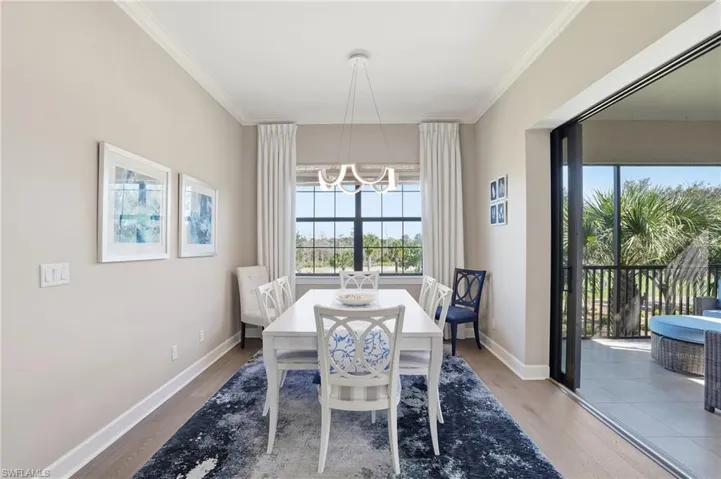 Dining room featuring light wood-style floors, a chandelier, and ornamental molding