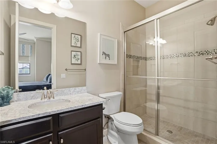 Full bath featuring vanity, connected bathroom, and a stall shower