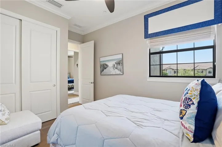 Bedroom featuring ornamental molding, a closet, wood finished floors, and a ceiling fan